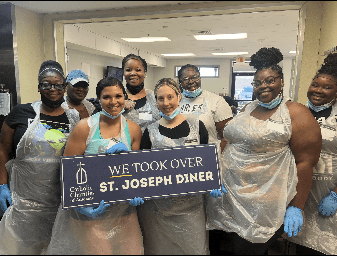 Volunteers at St. Joseph Diner holding a sign after serving the community